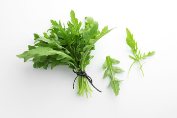 Fresh green arugula leaves on white background, flat lay