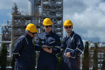 Engineer working using tablet together at station refining oil petrochemical. Technician worker check quality oil industry factory. Inspector standing at zone gas with refinery building background.