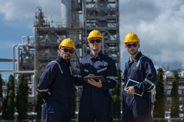 Engineer working using tablet together at station refining oil petrochemical. Technician worker check quality oil industry factory. Inspector standing at zone gas with refinery building background.