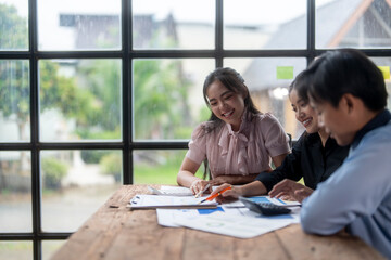 Team of young asian coworkers are discussing about financial reports in a luminous office