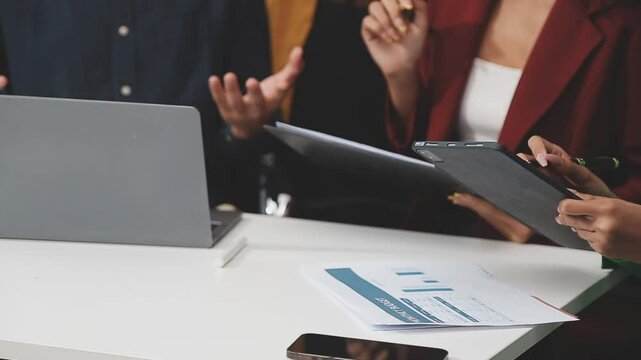 Professionals in a diverse group collaborate in a boardroom, engaging in a lively brainstorming session.