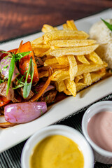 beef lomo saltado, french fries and rice, served with homemade creams, peruvian food