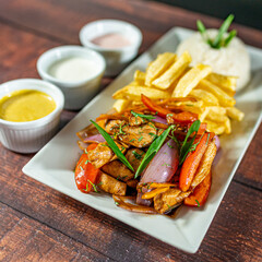 sautéed chicken with french fries and rice, served with homemade creams, peruvian food