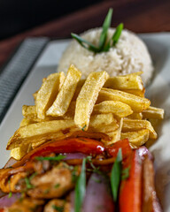 sautéed chicken with french fries and rice, served with homemade creams, peruvian food