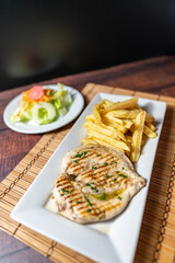 grilled chicken with french fries and fresh salad, accompanied by homemade creams.