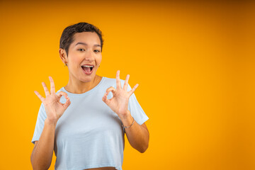 Young latin woman showing ok sign with both hands smiling