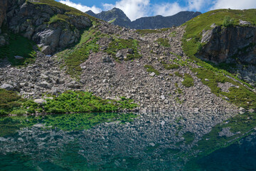 View of the Dukka lake "Rybka" on the Malaya Dukka River on the slopes of the Arkasar ridge in the North Caucasus on a sunny summer day, Arkhyz, Karachay-Cherkessia, Russia © Ula Ulachka