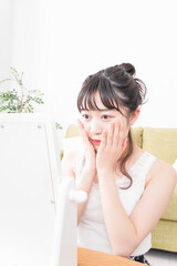 スキンケア・メイクをする若い女性