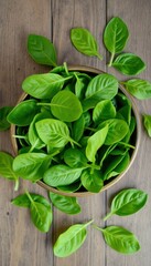 an overhead shot of a bowl full of vibrant green spinach leaves, with some leaves scattered around the bowl on a rustic wooden surface..