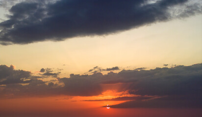 Beautiful sunset sky scenery. Bright colorful orange and yellow clouds on horizon