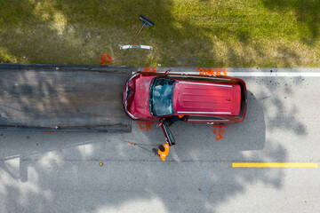 Car crash site with tow truck loading destroyed vehicle on American street. Emergency services...