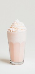 Delicious pink milkshake topped with whipped cream in a clear glass, perfect for summer refreshment and dessert indulgence.