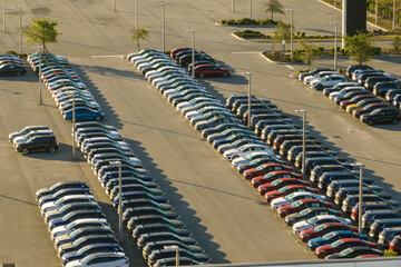 Obraz premium View from above of dealers outdoor parking lot with many brand new cars in stock for sale. Concept of development of american automotive industry