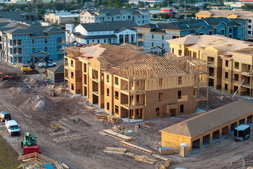 Wooden apartment buildings under construction in new developing suburban area. Development of...