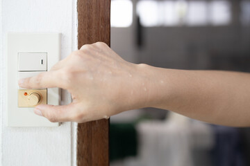 Close up,wet hand,asian woman using her finger to turn off the light switch after taking a...