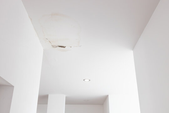 Damage to the ceiling surface of the room at home,dirty water stains,peeling paint on an interior ceiling,water leaked from roof,leaky roofs