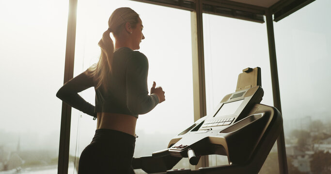 Woman, active and running on treadmill at gym for cardio exercise, workout and training performance. Fitness, female person and machine for morning routine, endurance or speed challenge of resilience