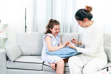 Asia mother and little daughter paint their nails with nail polish at home.Concept of good parenting and happy family.With holiday activities with family.