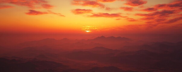 Obraz premium Sunset over misty mountains with vibrant sky