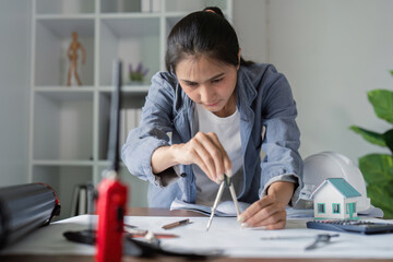 Engineer using compass for architectural drafting in office