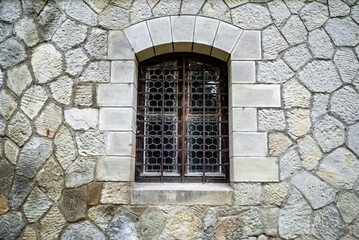 Rustic Barred Window on Stone Wall: Timeless Architecture and History