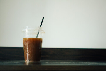 A plastic cup of americano coffee take away put on table