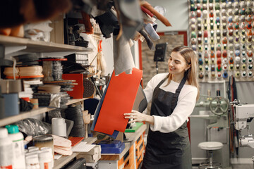 Woman tailor choosing a material leather sheet for her work