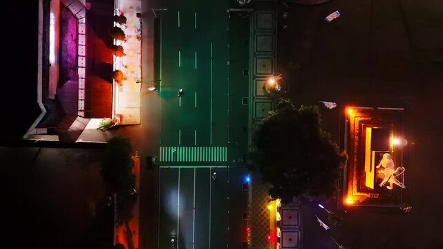 Top down night time drone footage of the illuminated boulevard of Magelang city, Indonesia.