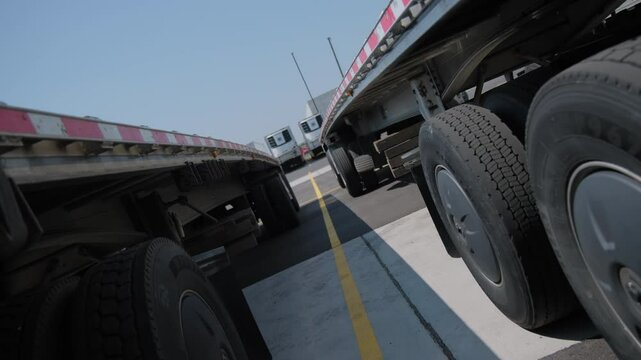 flatbed trailer and other trailers for semi-trucks in the parking lot. Move camera
