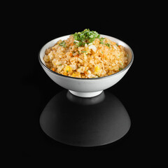 A bowl of delicious golden fried rice garnished with green onions, set against a black background. Perfect for culinary presentations.