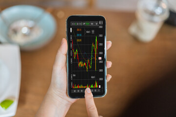 Hand hold smartphone with stock market chart financial trading, online investment, stock exchange analysis, market trends, real-time trading data, forex and crypto trading economic forecasting tool