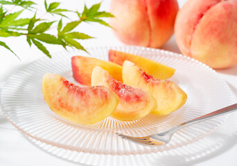 Cut peaches on a plate on white background.