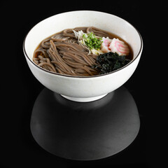 A delicious bowl of soba noodles served with fresh toppings on a sleek black background, capturing the essence of traditional Japanese cuisine.