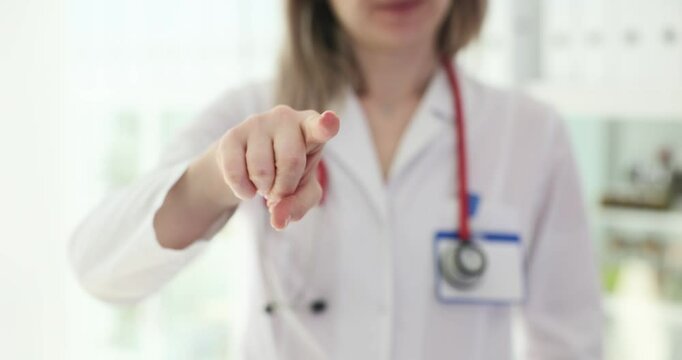 Female doctor points her index finger at camera