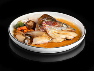 A delicious plate of steamed fish with vegetables, served in a savory brown sauce, ideal for culinary presentations and menus.