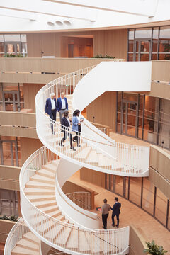 High angle view of corporate coworkers moving down on steps in modern office