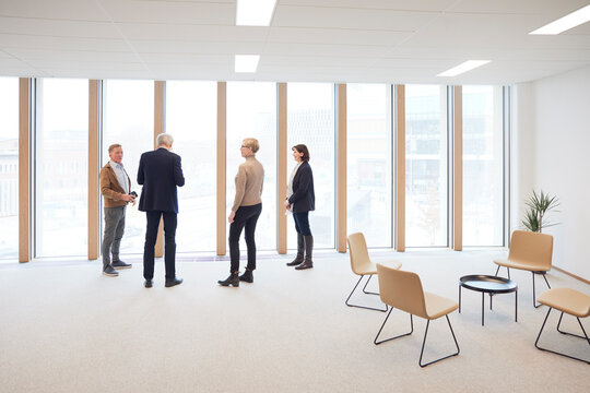 Corporate colleagues standing by window in office