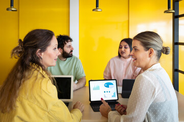 Young business colleagues discussing graph during meeting in office