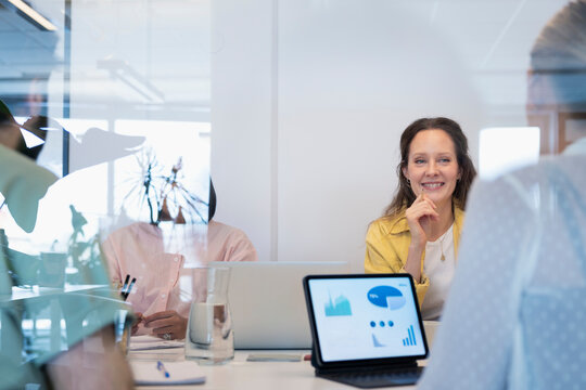 Smiling businesswoman discussing graph with female coworker while working in office
