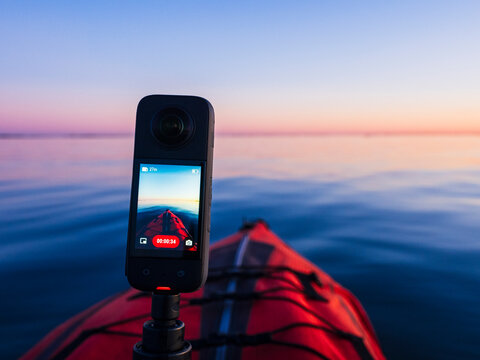 Camera on kayak filming sea at sunset