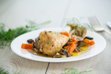 roast chicken with mushrooms and vegetables in a plate on a wooden table