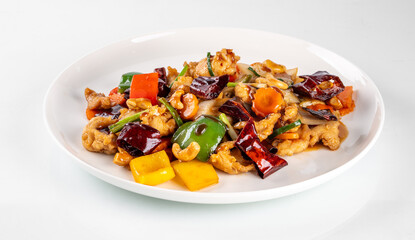 Close-up of a delicious stir-fry dish featuring chicken, colorful bell peppers, and cashews on a white plate, perfect for culinary visuals.
