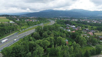 Winding road through green landscape with fields and houses