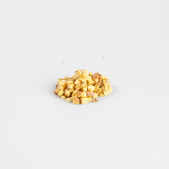 Close-up of a small pile of finely chopped dried apples isolated on a plain white background.