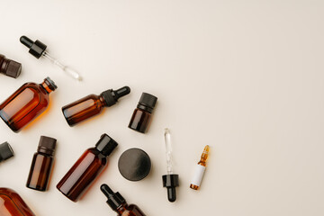 Various Amber Glass Containers for Essential Oils and Skin Care Products Displayed on Light Background