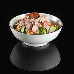 Delicious bowl of ramen featuring tender pork slices, fresh vegetables, and rich broth, artfully presented on a black background.