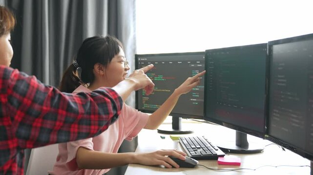 Slow motion back end software developer engineer for computer programming working together on debugging writing computing code, solving complex algorithms display on monitor in office. Burgeoning