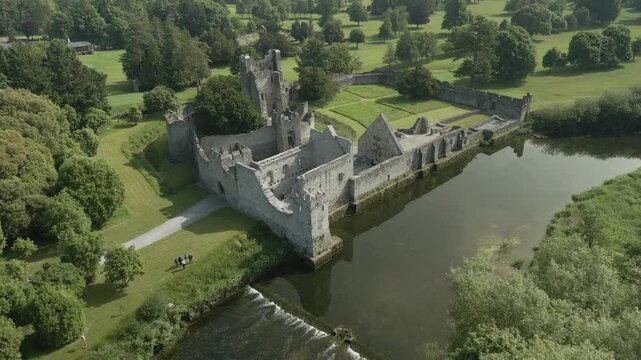 Adare castle by the river surrounded by lush greenery in county limerick ireland, aerial view