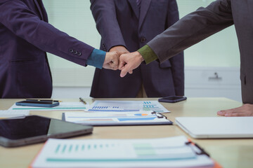 Close-up of business people shaking hands during a meeting in the office, discussing and analyzing charts,financial data,planning digital marketing projects together with business experts investors