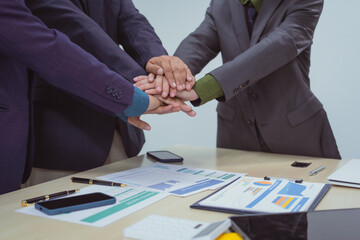 Close-up of business people shaking hands during a meeting in the office, discussing and analyzing charts,financial data,planning digital marketing projects together with business experts investors